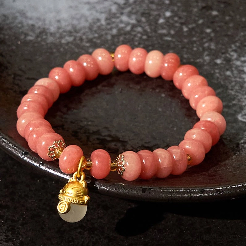 Beaded Jade Bracelet with Lucky Cat Charm and Pink Rondelle Stones - Flat Lay on Black Plate