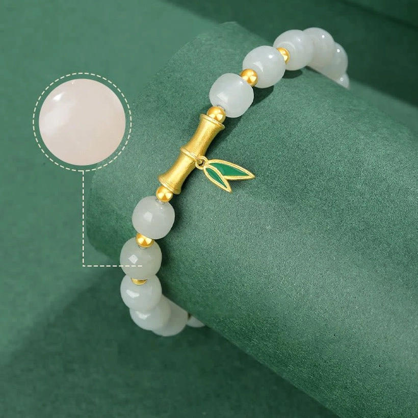 Side oblique view highlighting smooth white jade beads and precious metal hardware detail of bracelet