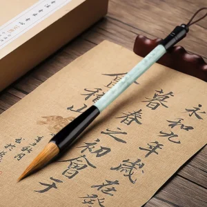 Single jade calligraphy brush on vintage Chinese calligraphy paper and wooden desk, showing traditional writing technique