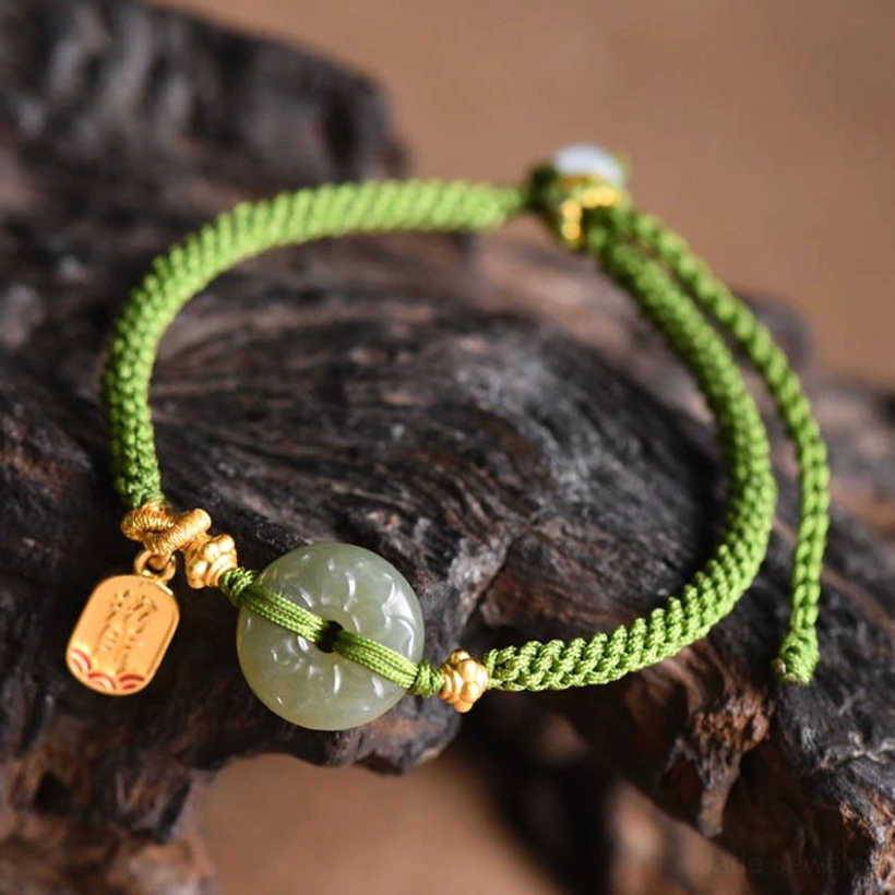 Polished green jade buckle bracelet with woven rope and gold drop charm flat lay