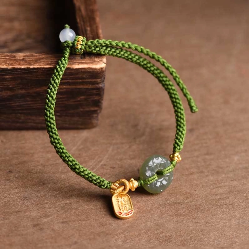 Carved jade peace buckle with engraved gold charm detailed close-up view