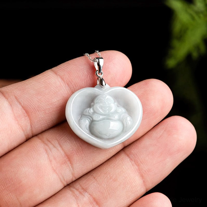 Mini heart-shaped laughing Buddha jade pendant held in human palm, showing scale and size dimensions