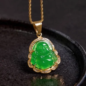 Green jade Buddha pendant with braided gold chain on dark circular tray - overhead view of complete necklace