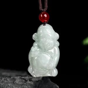 Handcrafted jade Caishen deity pendant showing smiling carved face holding ingot, front view with brown cord and red bead