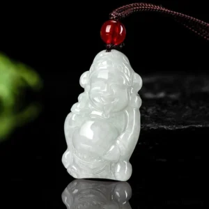 Natural jade Caishen god of wealth ingot pendant necklace with red agate bead on brown cord, top-down view on dark stone background