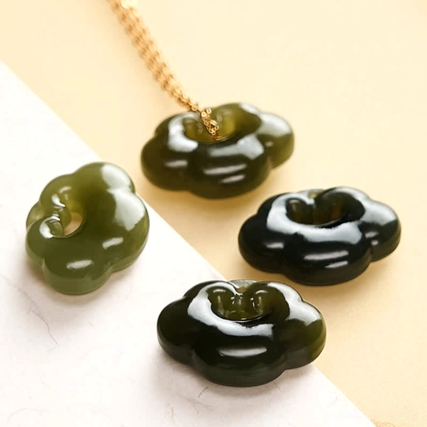 Collection of multiple Hetian jade cloud lock pendants in various green tones with sterling silver and copper chains display