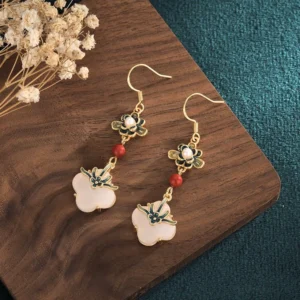 Handmade jade clover drop earrings with pearl accent and red agate bead flat lay styling