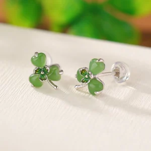 Pair of jade clover stud earrings with silver posts, side angle flat lay showing symmetrical design and craftsmanship detail