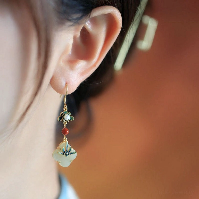 Four leaf clover jade drop earrings worn on ear showing enamel detail and clover pendant close-up