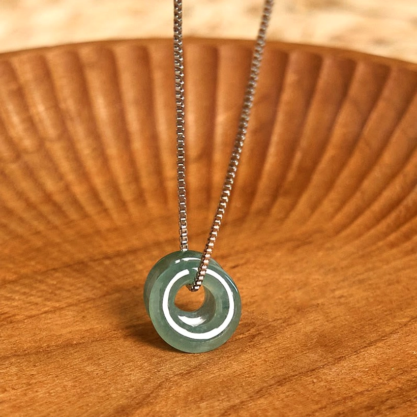 Double jade peace buckle prosperity necklace with silver chain, complete product view on neutral surface