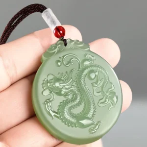 Jade dragon necklace held in hand showing brown wax cord with red decorative bead and white spacer bead accents