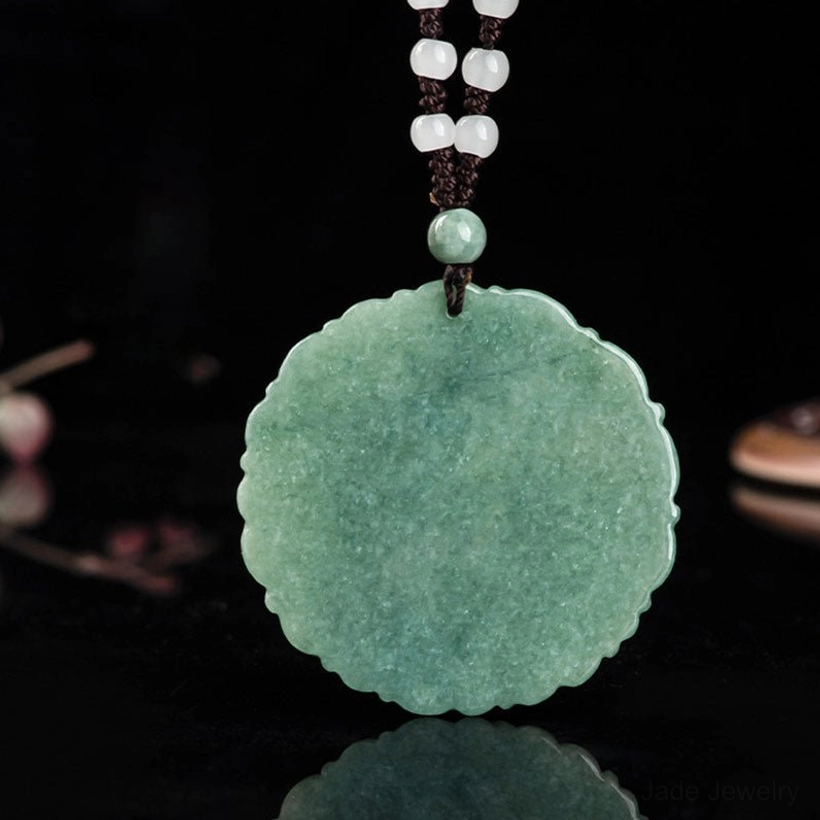 Back side of jade dragon pendant necklace showing smooth natural jade with simple white beaded hanging cord