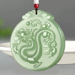 Hand-carved natural jade dragon pendant with cloud motif, top-down studio view showing full dragon relief and cloud-patterned hanger