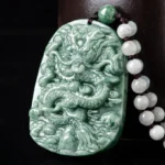Deep green jade dragon pendant necklace with relief-carved design and beaded cord