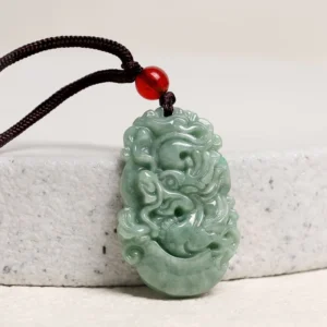 Hand-carved jade dragon zodiac pendant necklace, side profile showing three-dimensional relief carving on stone surface