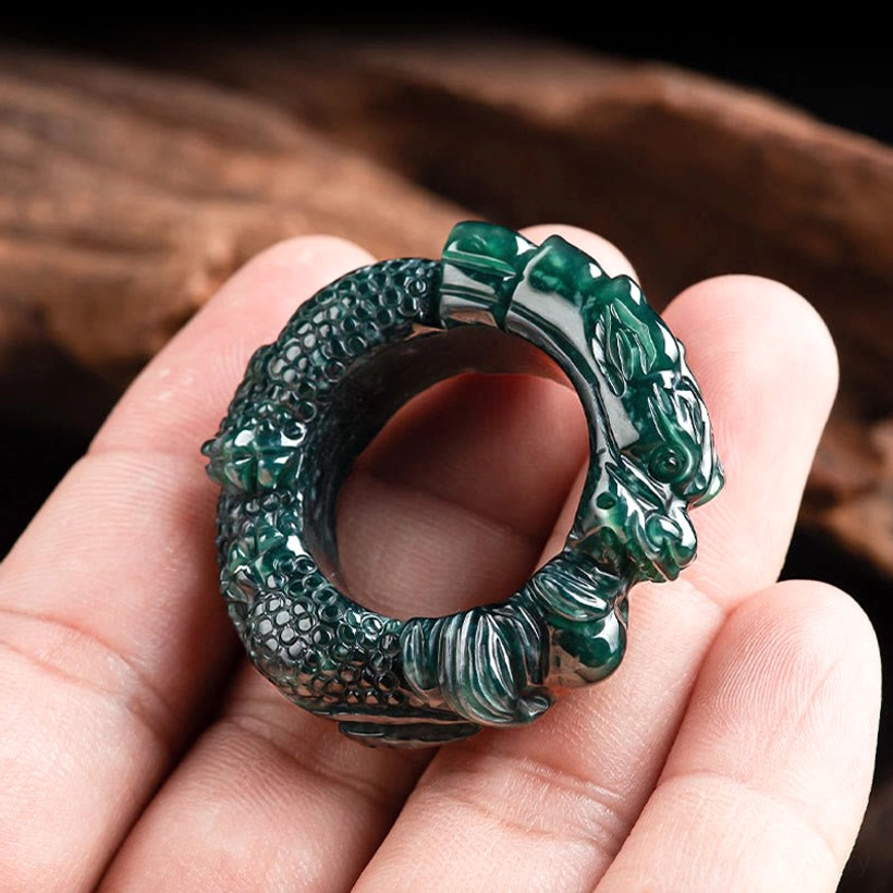 Cyan jade dragon ring held in palm showing scaled dragon details and dark green jade material fitting comfortably on finger