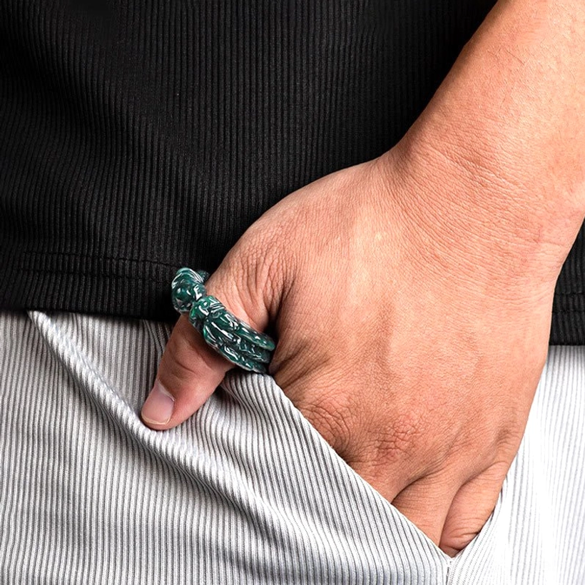 Cyan jade dragon ring worn on index finger with casual daily clothing background showing real-world wearability