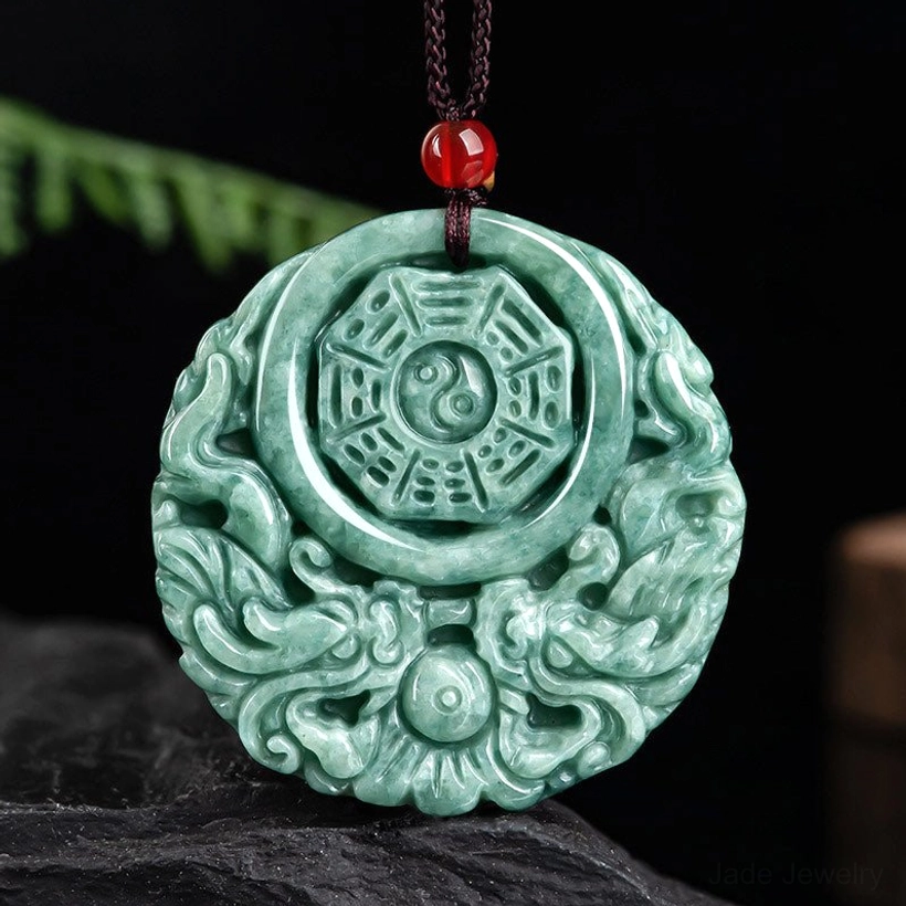 Green jade dragon yin yang necklace pendant with red accent bead on brown cord - front view