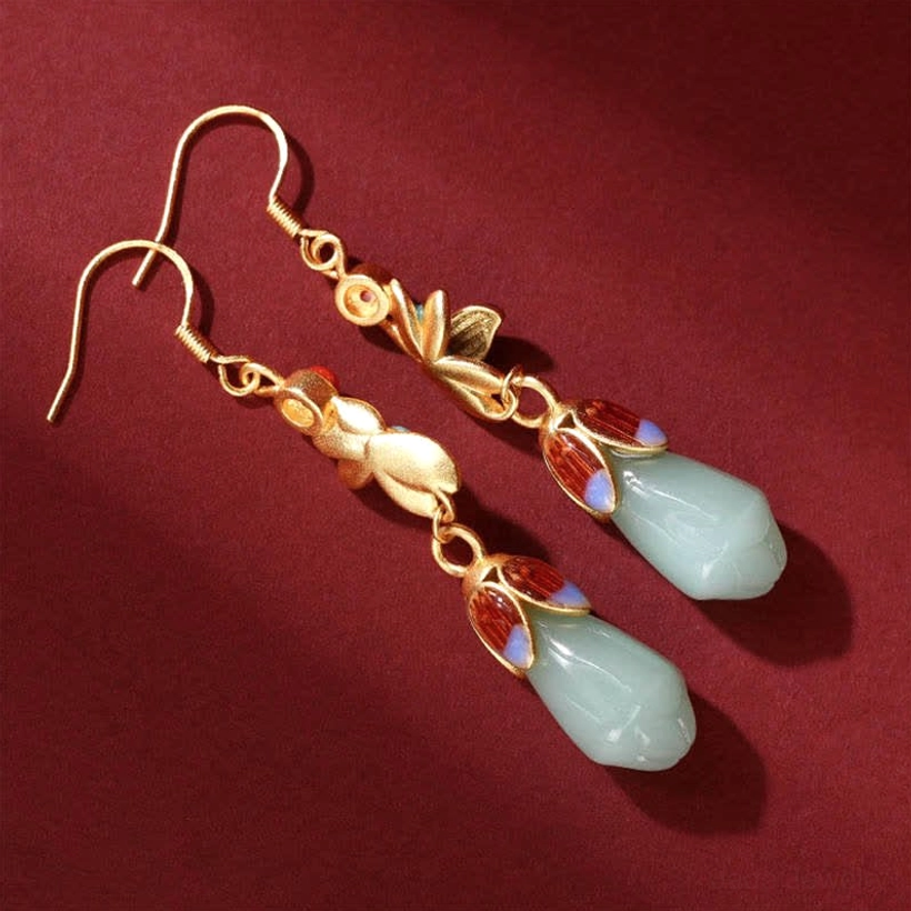 Oblique side view of leaf-themed jade drop earrings with gold leaf ornaments and red-blue enamel jade caps