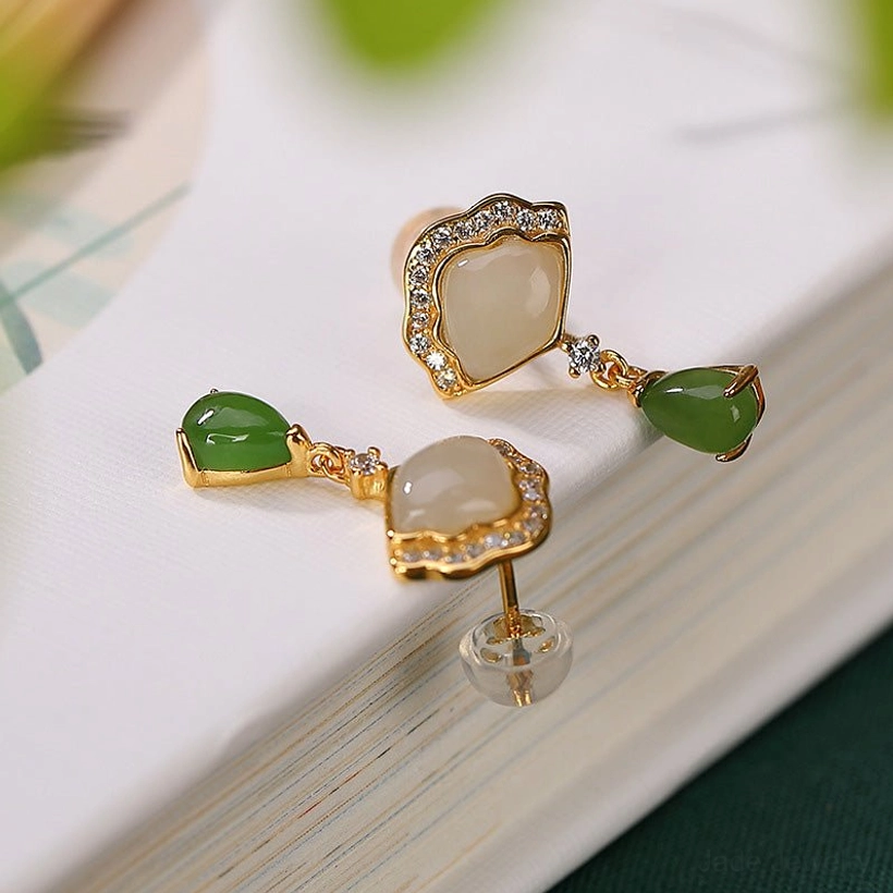 Two pairs of jade fan drop earrings with plastic backs on book cover