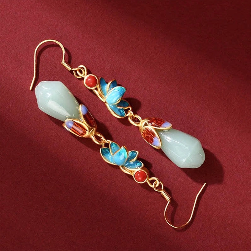 Side profile of jade drop earrings showing gold chain, light green jade buds, and blue-red enamel flower accents