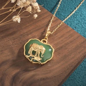 3D embossed gold elephant design on jade stone pendant necklace, overhead angle view showing polished green jade setting and fine copper craftsmanship