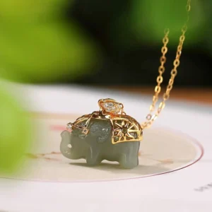 Jade elephant necklace overhead view displaying hollowed gold ornamental saddle and natural jade stone color variation