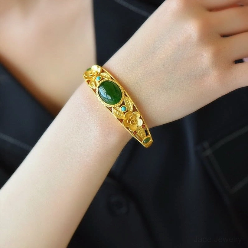 Elegant jade flower bangle bracelet worn on wrist, showcasing gold filigree design and floral carvings in lifestyle styling