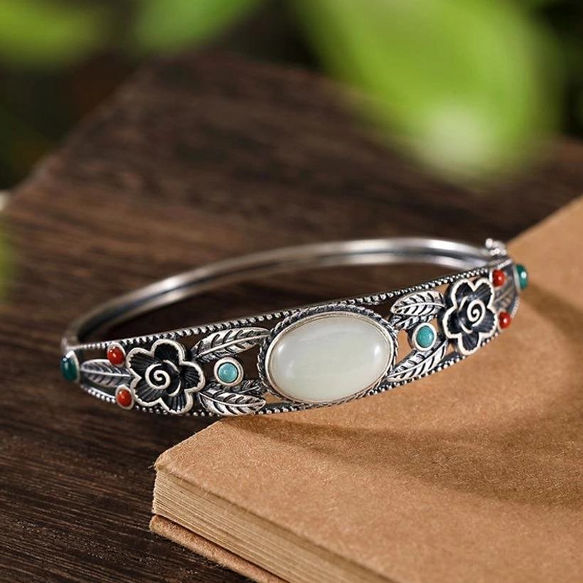 Cyan and white jade flower bangle collection, multiple color variations showing floral carving details and metal finishes