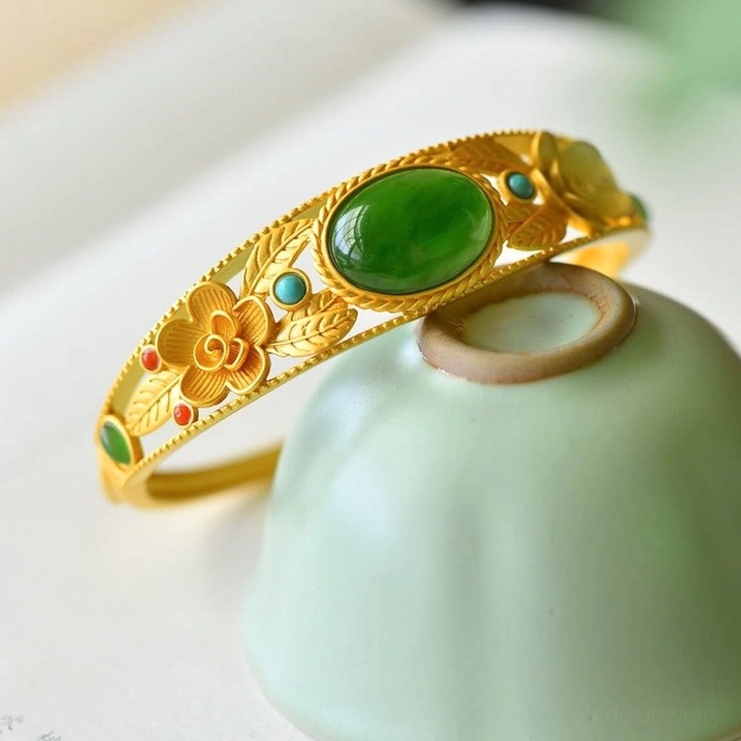 Handcrafted cyan and white jade bangle with floral carvings, oval green jade stone, and gold filigree metalwork