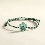 Hand-woven jade flower bracelet with adjustable elastic cord - side view showing natural jade charm detail