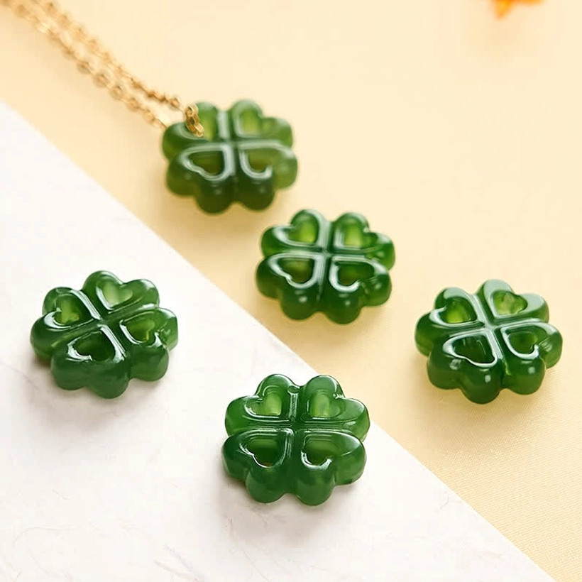Four natural Hetian jade four-leaf clover pendants loose carved charms overhead view