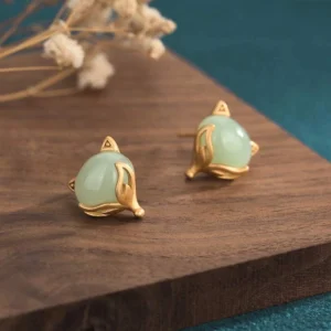 Hand-carved jade fox earrings three-quarter side view showing polished matte gold wrap setting and smooth jade stone detail