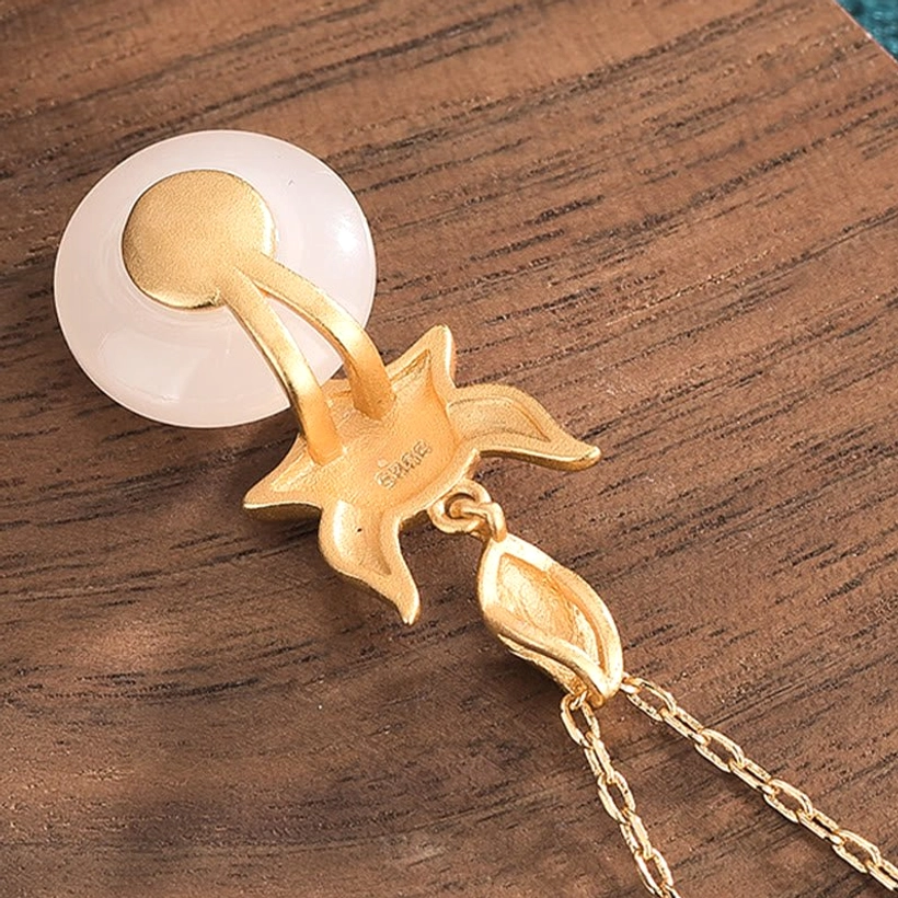 Back view of white jade fox necklace pendant showing metal mounting clasp and artisan maker's mark