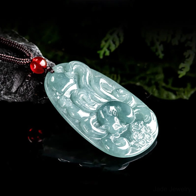 Side profile view of light jade nine-tailed fox pendant necklace with brown rope and red decorative bead