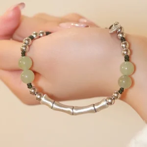 Fu jade bamboo silver bracelet worn on wrist with adjustable silver clasp and elastic drawstring, close-up view