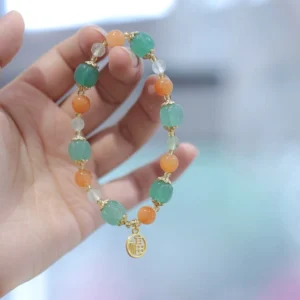 Fu charm beaded jade bracelet side view on single hand, highlighting dangling Fu character charm with natural stone beads