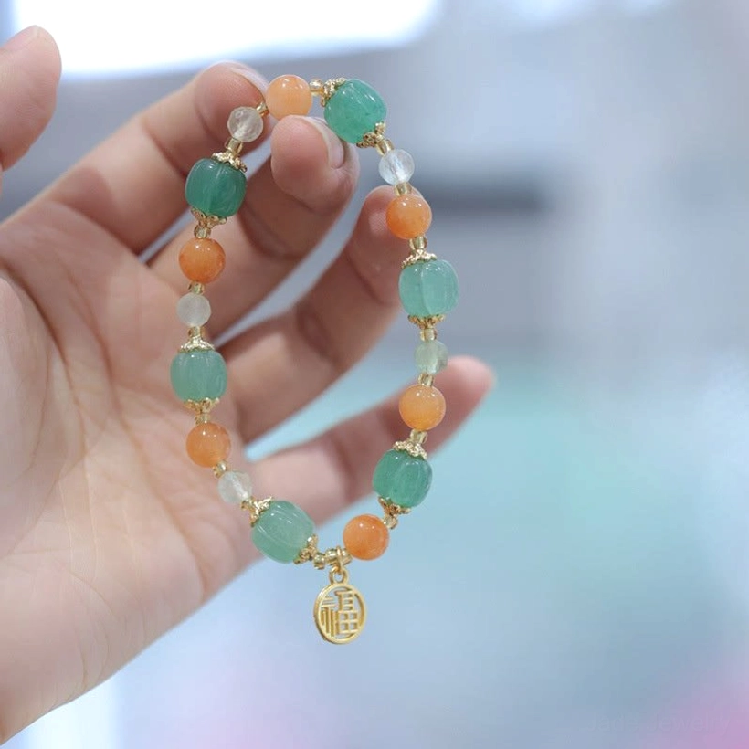 Fu charm beaded jade bracelet side view on single hand, highlighting dangling Fu character charm with natural stone beads