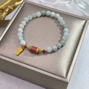 Natural jade Fu character prayer wheel prosperity bracelet in luxury gift box, featuring light green jade beads with gold Fu charm and red accent beads