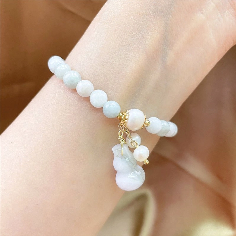 Dainty light blue jade beads with gold accents and gourd charm on arm