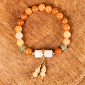 Golden Silk Jade and white crystal gourd tassel bracelet top-down view showing mixed stone beads and gourd pendant