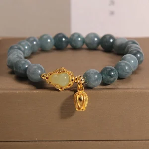 Natural blue-grey jade gourd charm bracelet with gold-toned hardware, displayed on luxury brown jewelry gift box