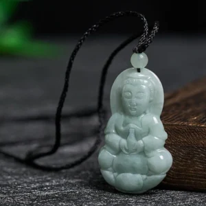 Jade Avalokitesvara pendant necklace three-quarter angle showing carving detail and adjustable black cord on wooden display block