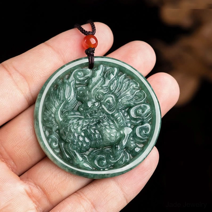 Close-up hand-held view of natural jade kirin pendant showing intricate carving details