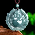 Natural jade laughing Buddha lotus pendant necklace front view on wooden base with green foliage background