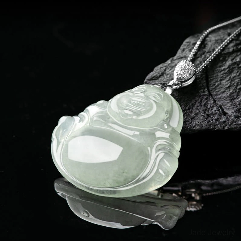 Natural jade laughing Buddha pendant low angle view showing translucent light green jade with silver metal hardware