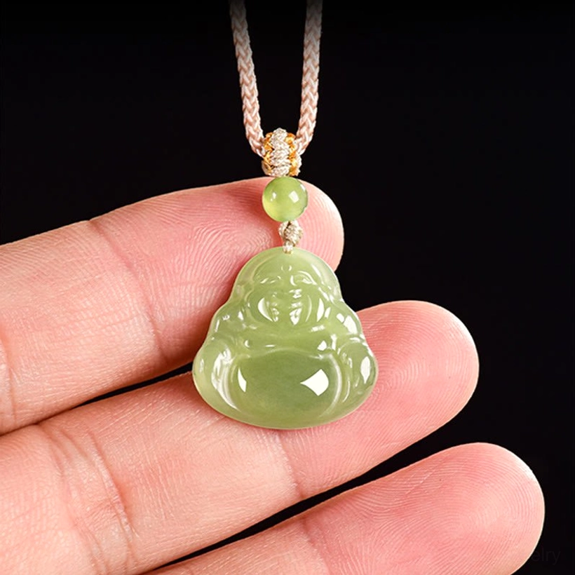 Close-up of jade Laughing Buddha pendant held in hand showing natural color and rope texture