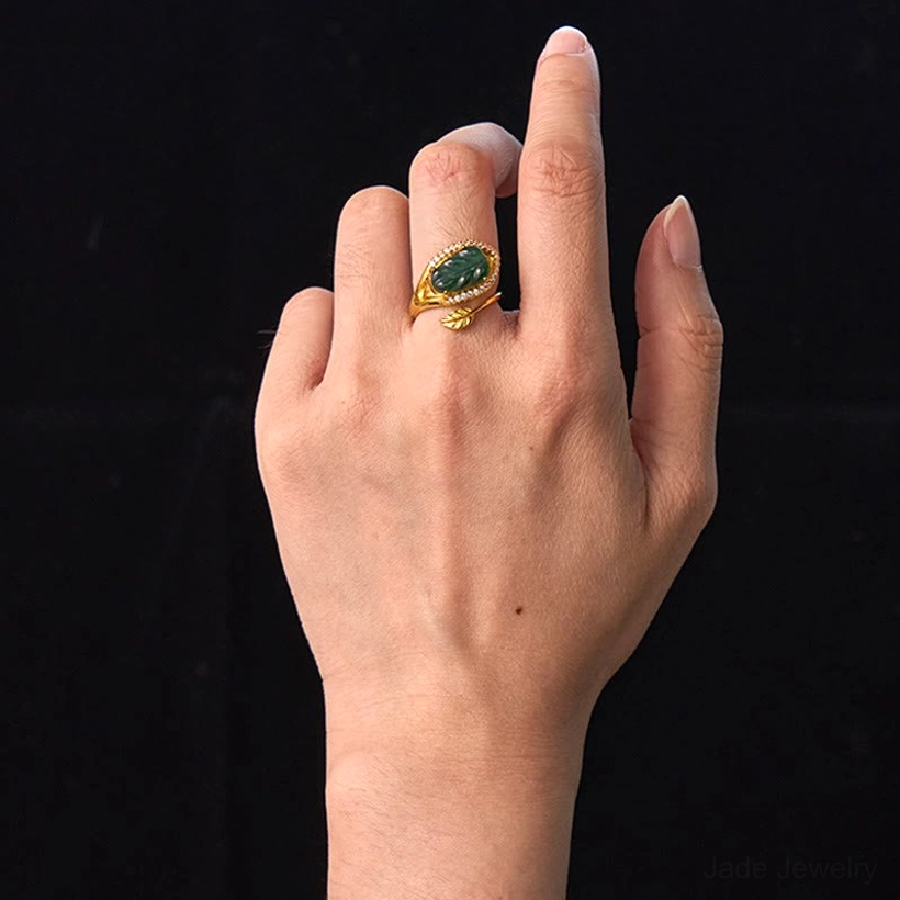Natural jade leaf adjustable ring worn on hand - front view demonstrating proper fit and comfortable adjustment for different finger sizes against neutral background
