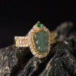 Natural jade leaf diamond ring front three-quarter view showcasing carved green jade stone with gold-plated copper band and cubic zirconia diamond halo setting