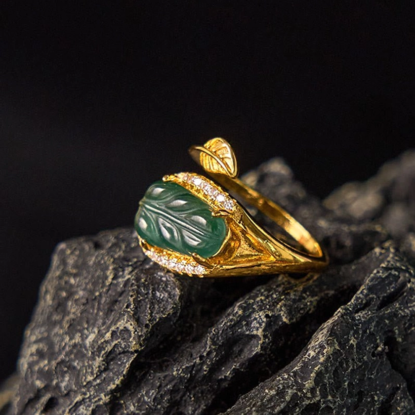 Natural jade leaf gold ring - rear view showing the carved jade leaf and intricate crystal-trimmed metalwork details on dark stone surface